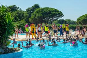 a group of people in the water at a swimming pool at Domaine Les Mûriers in Vendres-Plage