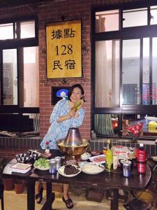 a woman standing in a kitchen preparing food at Sronghld 128 B&B in Jinning