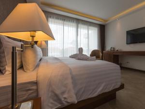 a bedroom with a bed with a lamp and a tv at Action Point Weight loss and Fitness Resort in Rawai Beach