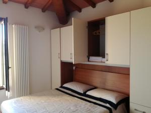 um quarto com uma cama e armários e uma janela em Finestra Della Val D'Orcia em Contignano