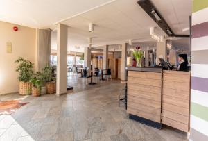 un hall de bureau avec une femme assise à un bureau dans l'établissement Sure Hotel by Best Western Dahls, à Löddeköpinge