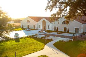 a large white house with cars parked in the driveway at Appartements Chais Monnet in Cognac