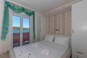 a bedroom with a bed and a large window at Villa Rossa Apartments in Rab
