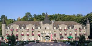 a large building with a clock on the front at Floreal La Roche-en-Ardenne in La Roche-en-Ardenne
