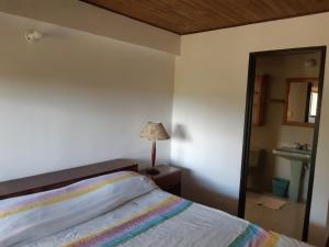 a bedroom with a bed and a lamp and a mirror at Finca Paraíso in Calima