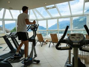 een man op een loopband in een sportschool bij Family Hotel Gutenberg in Schenna