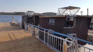 uma doca com uma casa e um barco nela em Hausboot Krakow am See Forelle 1 und 2 em Krakow am See