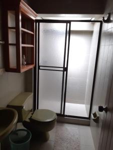a bathroom with a toilet and a glass shower at Finca Paraíso in Calima