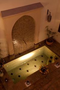 a swimming pool in a room with a tile floor at Riad Aubrac in Marrakesh