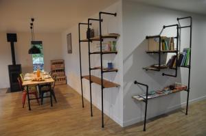 una habitación con una mesa y una pared con estanterías en L'Atelier en Sainte-Marie-du-Lac-Nuisement 