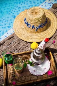 a straw hat and a drink on a table at Riad Ayadina & SPA in Marrakesh