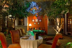 a restaurant with a table and chairs and a chandelier at Riad Ayadina & SPA in Marrakesh