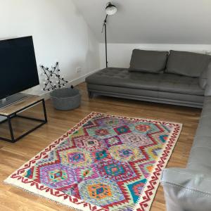 sala de estar con sofá y alfombra en Le Loft Deveney-Mars en Puligny-Montrachet