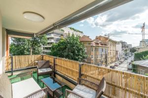 einen Balkon mit Stühlen und Straßenblick in der Unterkunft Luxury-Central Apartment-Victoriei Square-Subway in Bukarest