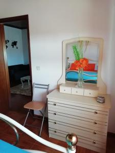 a dresser with a mirror and a vase on it at Casa Da Zu in Tomar