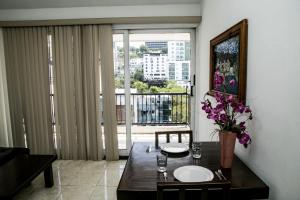 a dining room with a table and a large window at Booking Dioh in Monterrey