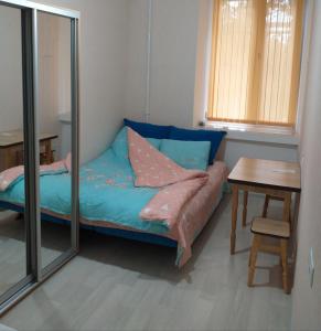 オデッサにあるOld Odessaのベッド、テーブル、鏡が備わる客室です。