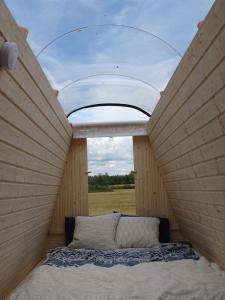 a bed in a small room with a window at Niiralan Tila: Skylight Cabin in Laitila