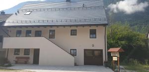 une maison blanche avec un toit noir dans l'établissement APARTMAJI VITEZ, à Bovec