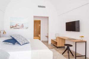 a bedroom with a bed and a desk and a tv at Palazzo Mulini in Monopoli