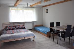 a bedroom with a bed and a table and a dining room at Ziołowy Zakątek in Jedlina-Zdrój