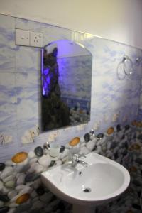 La salle de bains est pourvue d'un lavabo et d'un miroir. dans l'établissement Cascade Vally, à Ella