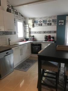 een keuken met witte kasten en een zwarte tafel bij l appart de Lilly in Pierry +10 foto's