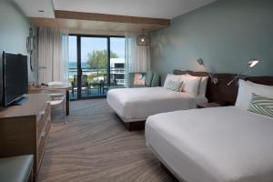 a hotel room with two beds and a flat screen tv at Zota Beach Resort in Longboat Key