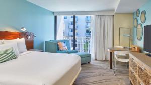 a hotel room with a bed and a chair and a desk at Zota Beach Resort in Longboat Key