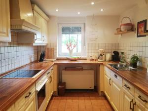 a kitchen with wooden counters and a sink and a window at Ferienhaus ELPARE in Schleife