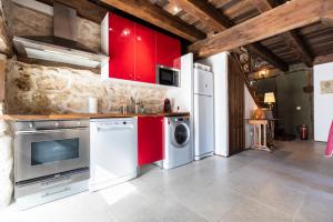 a kitchen with red cabinets and a washer and dryer at Alojamiento rural, Adrados Mar de Pinos in Adrados