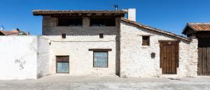 an old stone building with windows and a door at Alojamiento rural, Adrados Mar de Pinos in Adrados