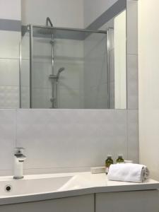 La salle de bains est pourvue d'un lavabo et d'un miroir. dans l'établissement Ultra Apartments Nautica, à Szczecin