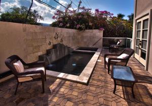 une terrasse avec une piscine, des chaises et une table dans l'établissement Hale Honu - Spectacular Oceanfront Home w/ central A/C Wading Pool & Hottub, à Kailua-Kona