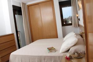 a bedroom with a bed with a book on a table at APARTAMENTOS SERRELLA - Rural Guadalest in Benimantell