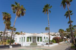a white house with palm trees in front of it at Apartment Eden Island Village in Adeje
