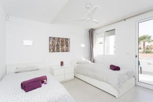 two beds in a white room with a window at Apartment Eden Island Village in Adeje +36 photos