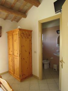 a bathroom with a toilet and a wooden cabinet at Fondo Riso in Faenza