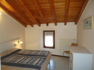 een slaapkamer met 2 bedden en een raam bij Casa Enrica Typ E2 in Crone