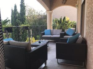 un patio con divani e tavoli su un balcone di Bouzigues Suite Parentale Étang de Thau a Bouzigues
