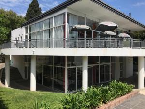 a building with a balcony with umbrellas on it at Apartamento en Country Pilar Piscina Parrilla propia hasta 4 personas in Pilar