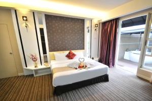a hotel room with a bed and a large window at The Sterling Boutique Hotel Melaka in Malacca