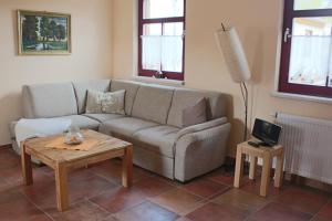 ein Wohnzimmer mit einem Sofa und einem Tisch in der Unterkunft Südhof Döbbrick - Ferienhof für Familienurlaub in Cottbus