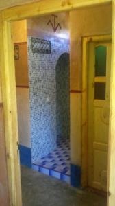 a room with a door and a tile wall at Auberge Des Jardins du Dades in Boumalne