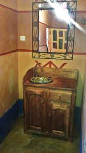 a bathroom with a wooden sink and a mirror at Auberge Des Jardins du Dades in Boumalne
