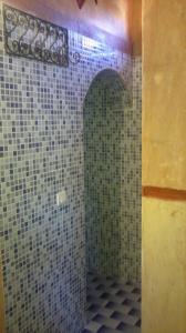 a bathroom with green and white tiles on the wall at Auberge Des Jardins du Dades in Boumalne