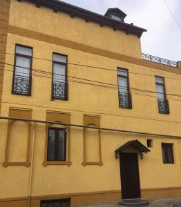 un edificio amarillo con ventanas y una puerta en Vincent, en Tiflis