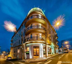 a building on the corner of a street at night at Planalto Select Hotel Ponta Grossa in Ponta Grossa