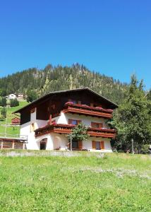 ein Gebäude auf einem Hügel neben einem Feld in der Unterkunft Cesa de Conesel in Colle Santa Lucia