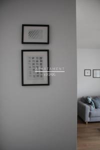een woonkamer met twee ingelijste foto's aan een muur bij Apartament KOSMOS in Toruń